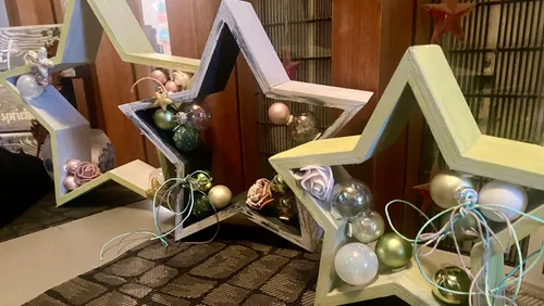 Wooden star decorations with ornaments indoors.