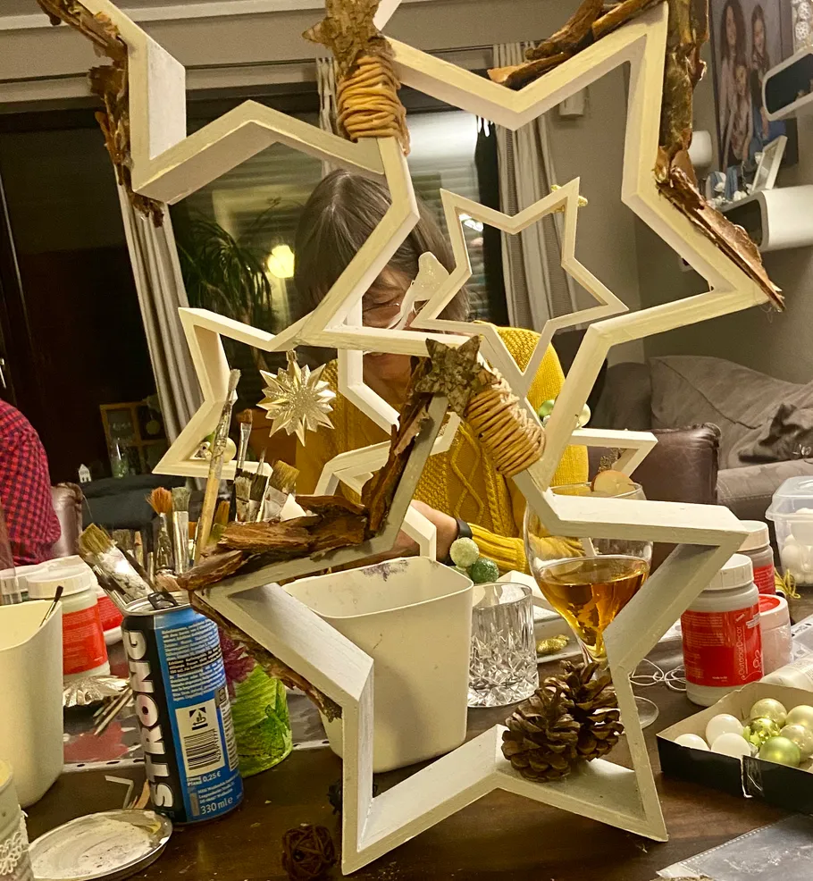 Person crafting star decorations at table.