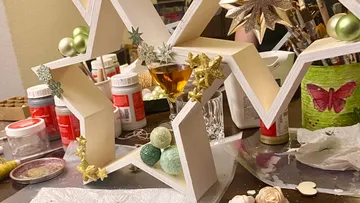 Wooden stars decorated with balls on a table.
