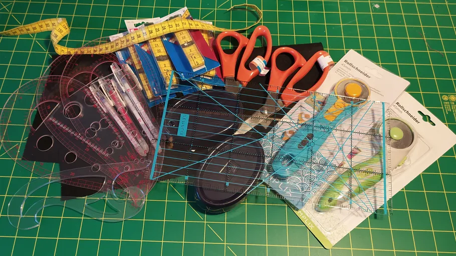 Sewing tools scattered on a green cutting mat.