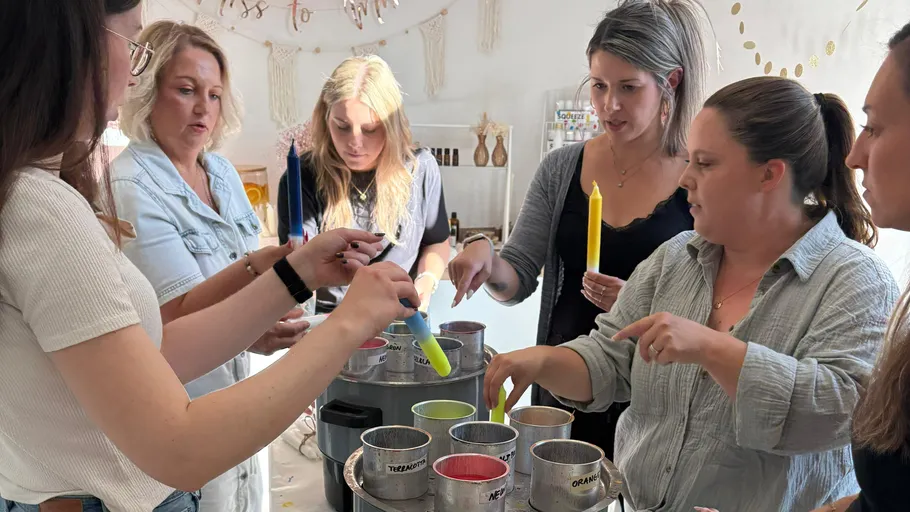 Women making candles in a workshop setting.