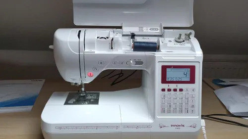 Sewing machine on table, digital display active.