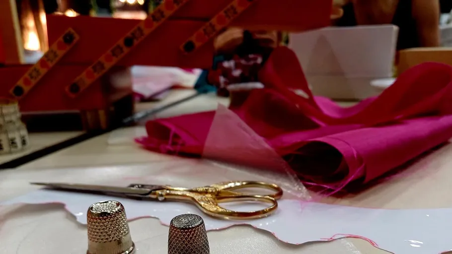 Sewing supplies on a table, scissors, and needle.