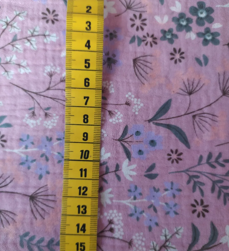 Measuring tape on floral pink fabric.