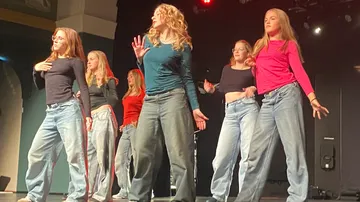 Gruppe von Frauen tanzt auf der Bühne in Freizeitkleidung.