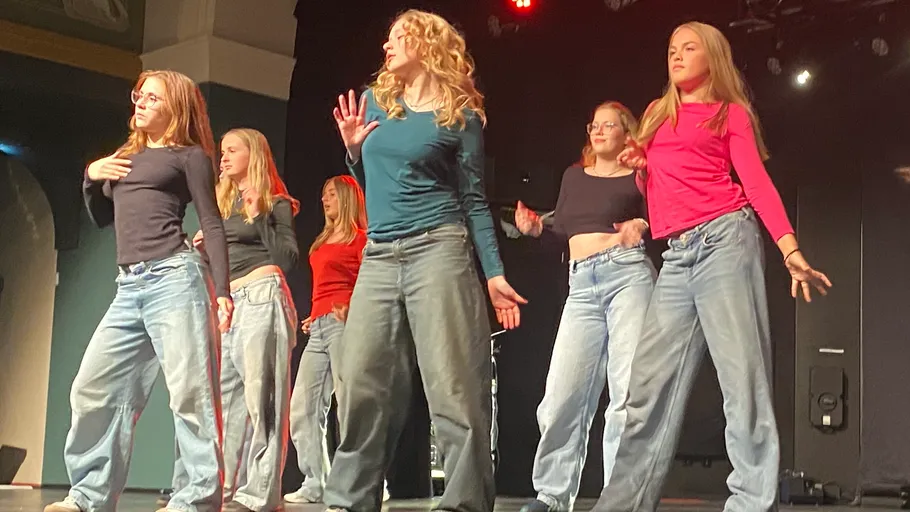 Gruppe von Frauen tanzt auf der Bühne in Freizeitkleidung.