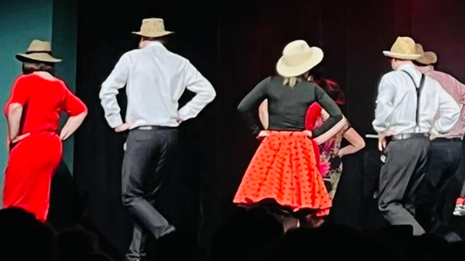 People in hats dancing on stage.