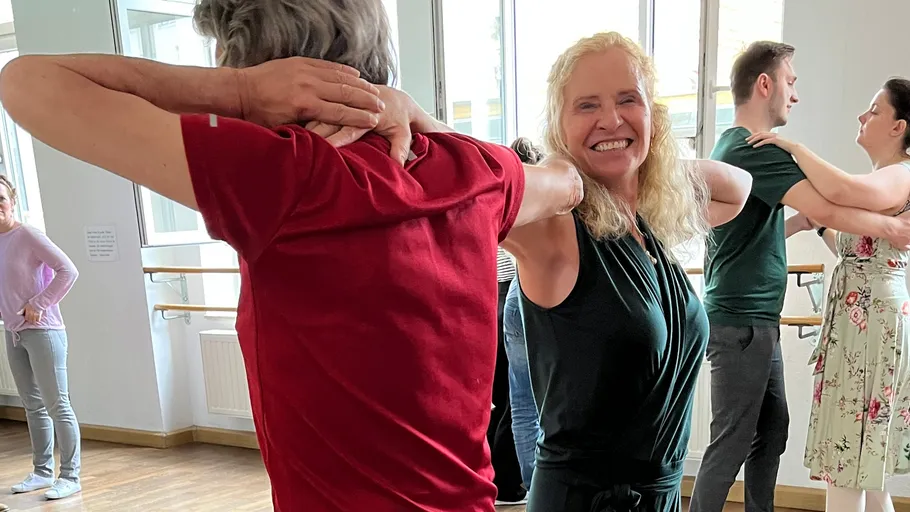 Menschen tanzen in einem hellen Studio.