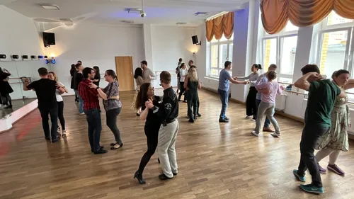 Couples dancing in a bright dance studio.