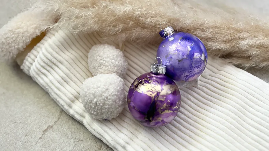 Zwei violette Ornamente auf weißer Mütze.