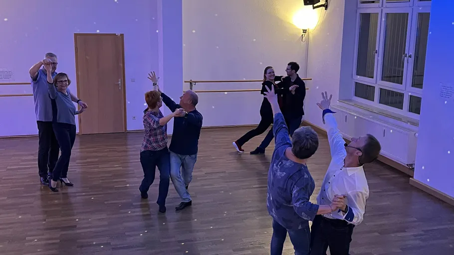Couples dancing in a dimly lit room.