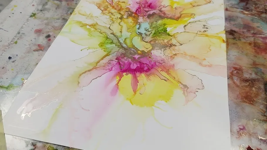 Buntes abstraktes Gemälde auf weißem Papier.