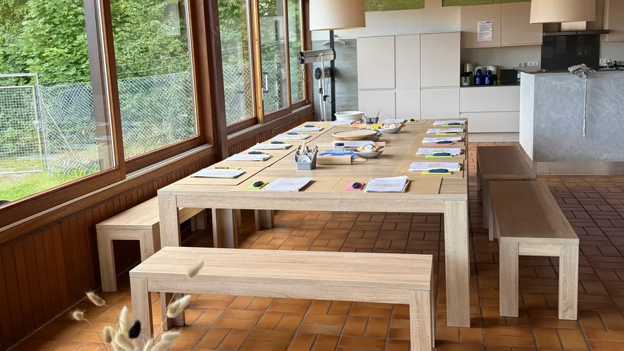 Vorbereiteter Tisch mit Bänken in Küche.