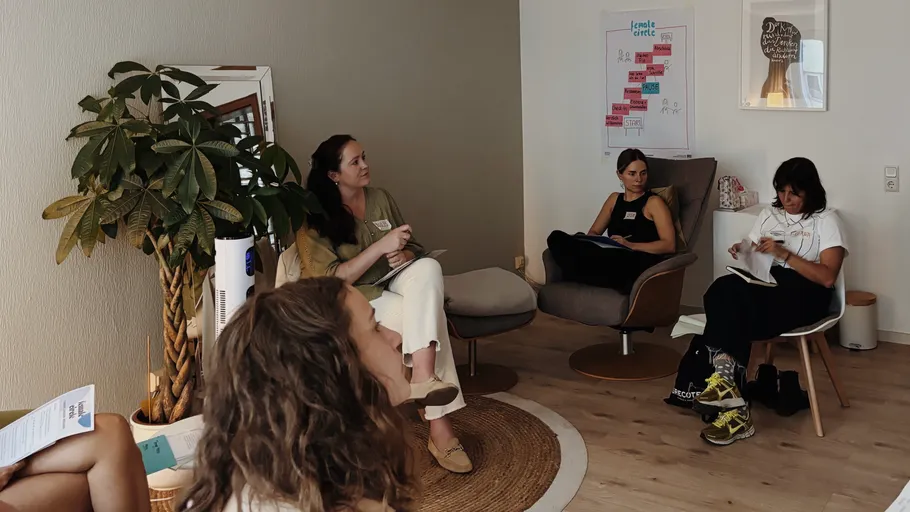 Women sitting and discussing in a cozy room.