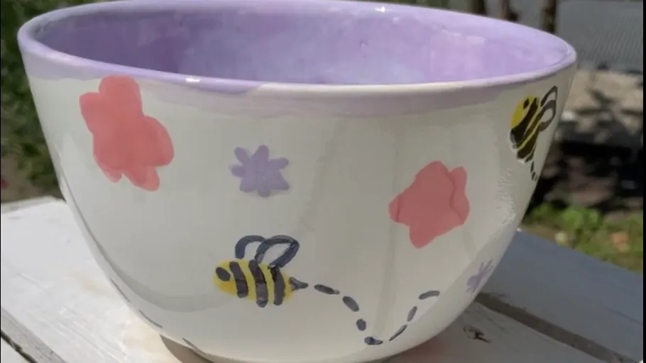 Dekorative Schüssel mit Bienen- und Blumendesigns.