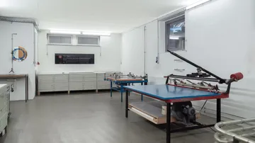 Empty print studio with worktables and equipment.