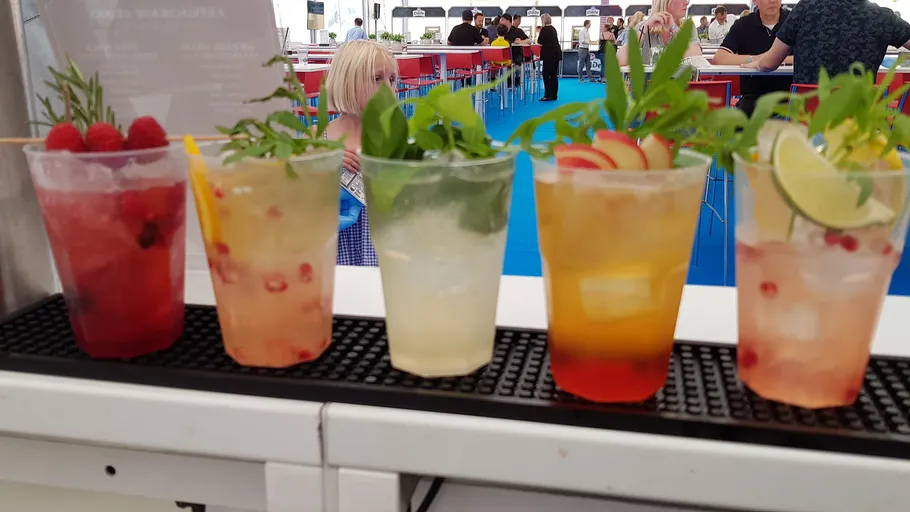 Fünf bunte Cocktails auf der Theke.