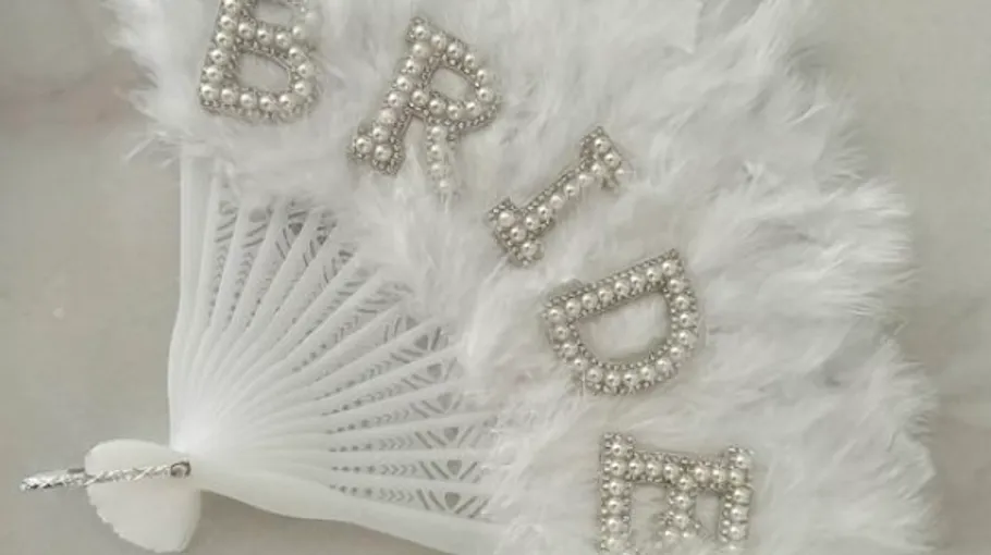 White feather fan with 'BRIDE' in pearls.