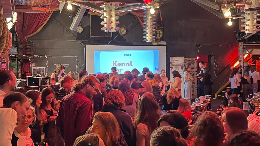 Crowd mingling in a dimly lit venue.