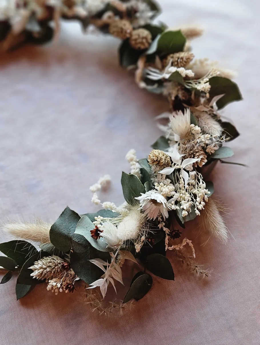 Floral wreath with dried flowers on table.