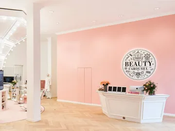 Empfangstheke mit `BEAUTY CAROUSEL`-Schild in modernem Salon.