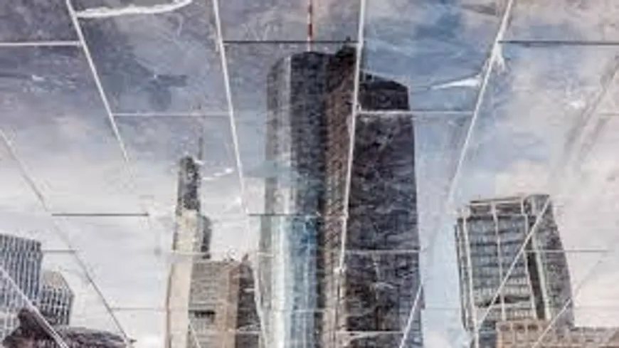 Skyscrapers reflected in fragmented glass structure.