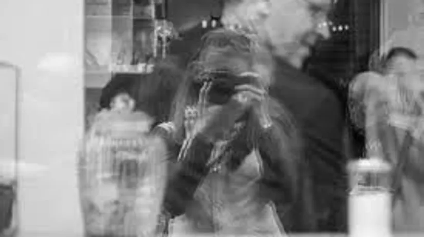 Double exposure shows photographer and people indoors.