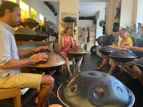 Menschen spielen Handpan in einem hellen Raum.