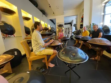 Five people play Handpan together in a music store.