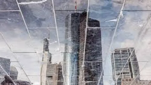 Skyscrapers reflected in broken glass exterior.