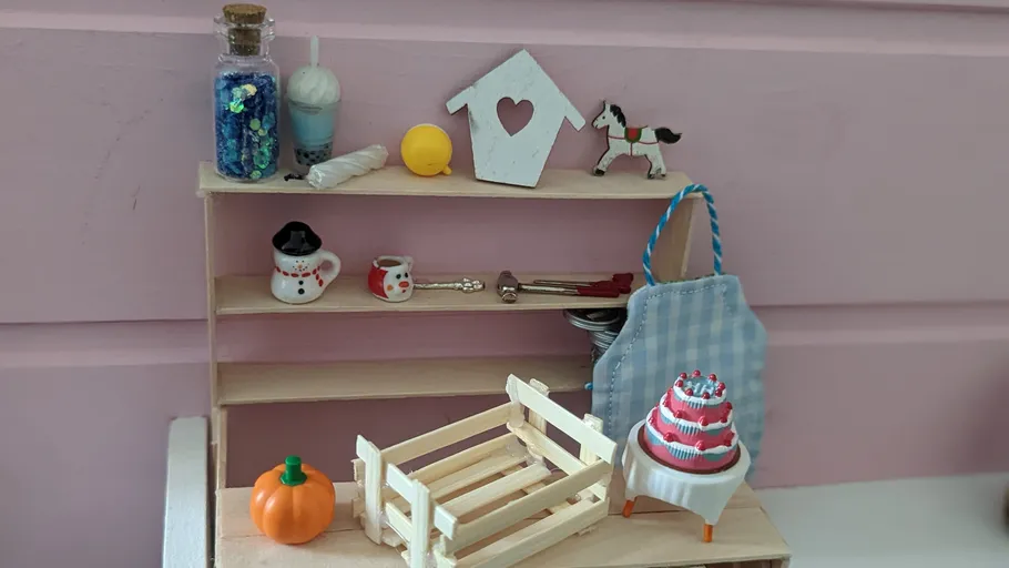 Miniaturen auf Regal vor rosa Hintergrund.