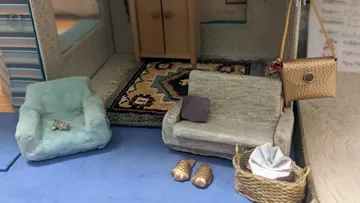Miniature furniture set in cozy dollhouse room.