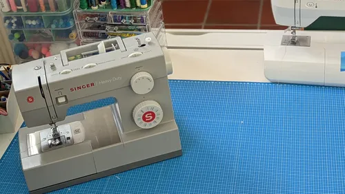 Sewing machines on a blue cutting mat.