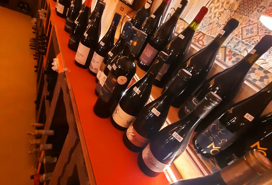 Wine bottles displayed on a wooden shelf.