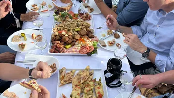 People dining, sharing assorted dishes on table.