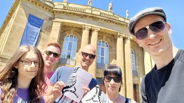 Gruppe posiert vor einem historischen Gebäude.