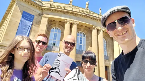 Group posing in front of a historic building.