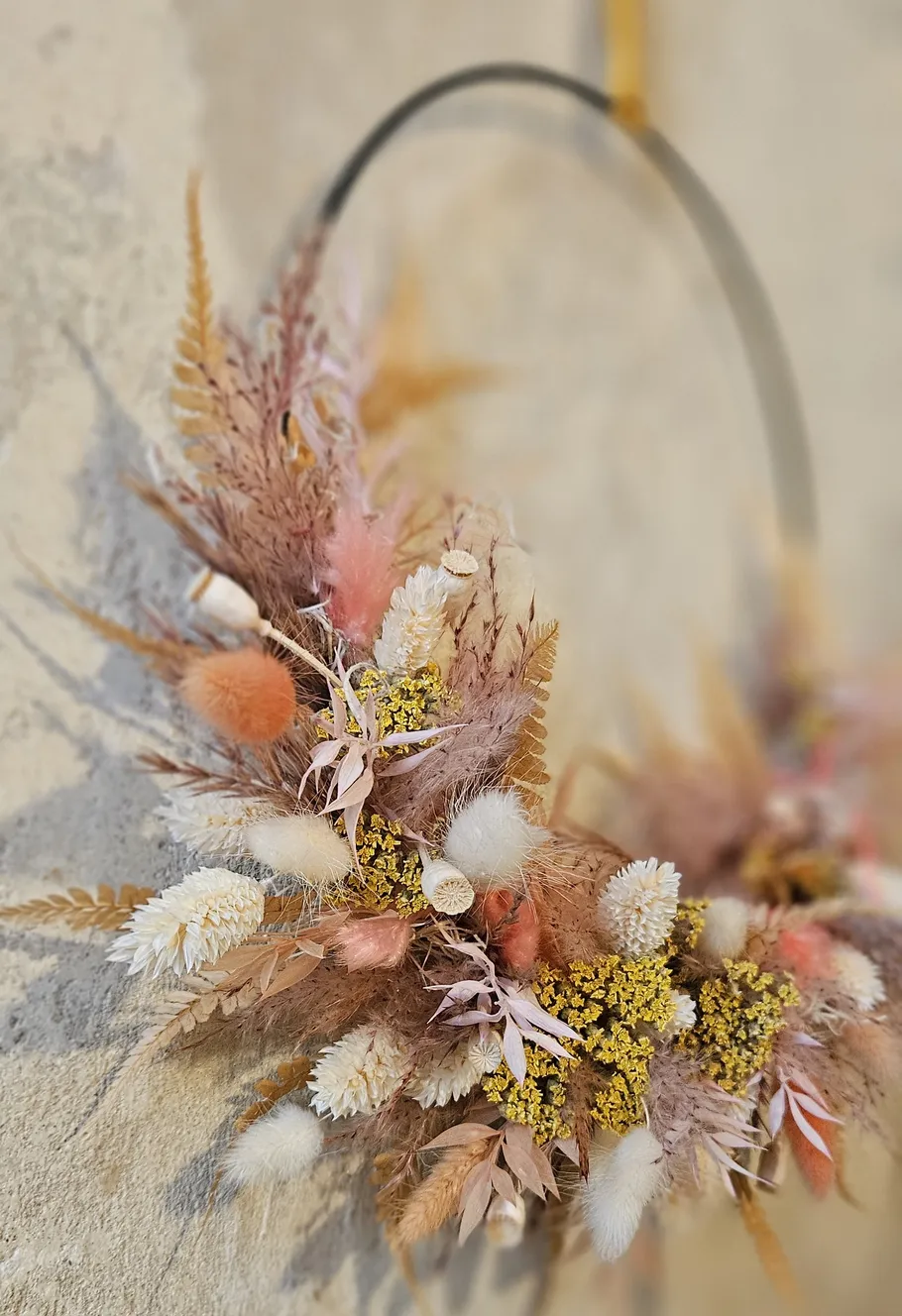 Colorful dried floral wreath on wall.