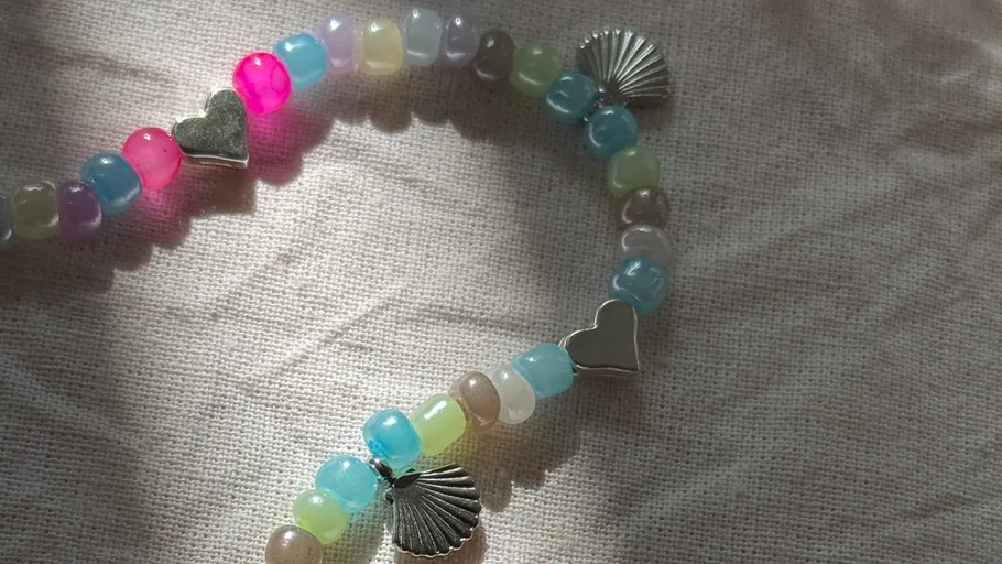 Beaded bracelets with charms on fabric.