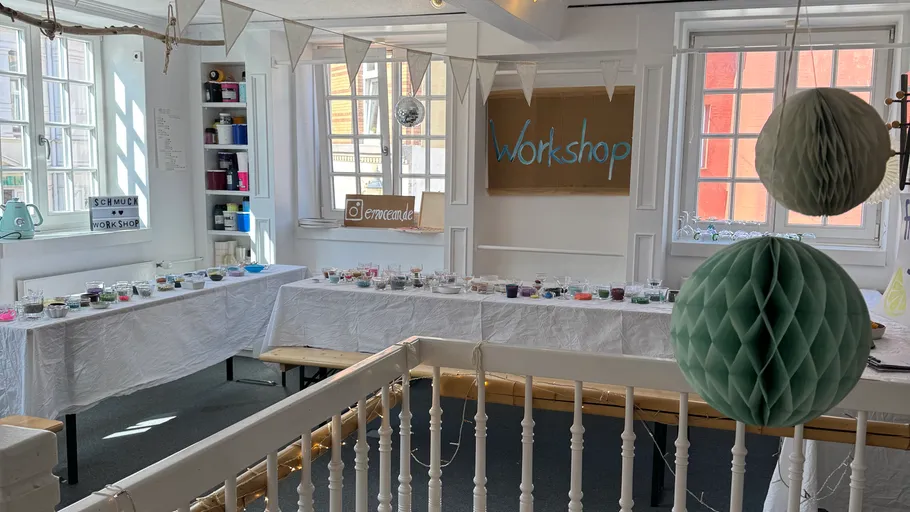 Workshop tables with crafts in decorated room.
