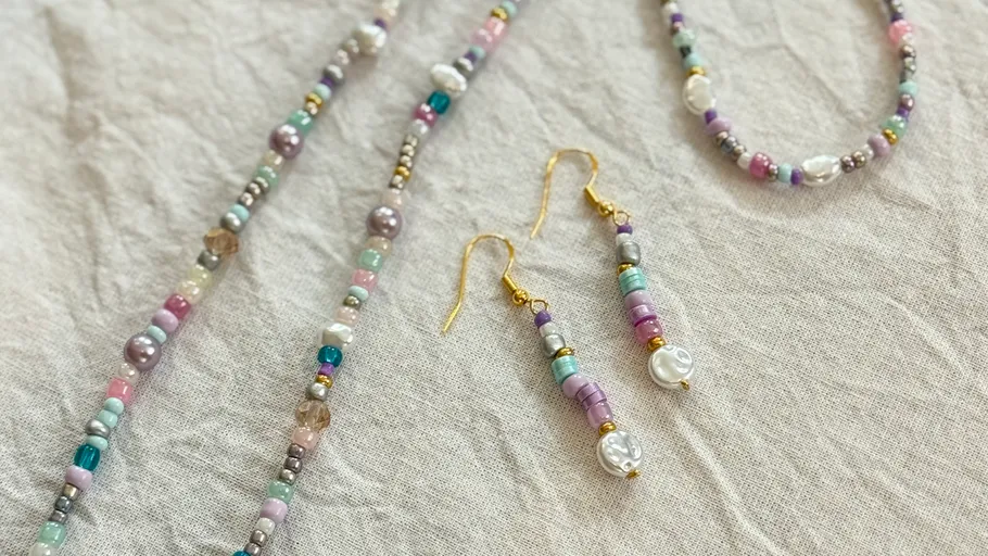 Colorful beaded jewelry set on a fabric surface.