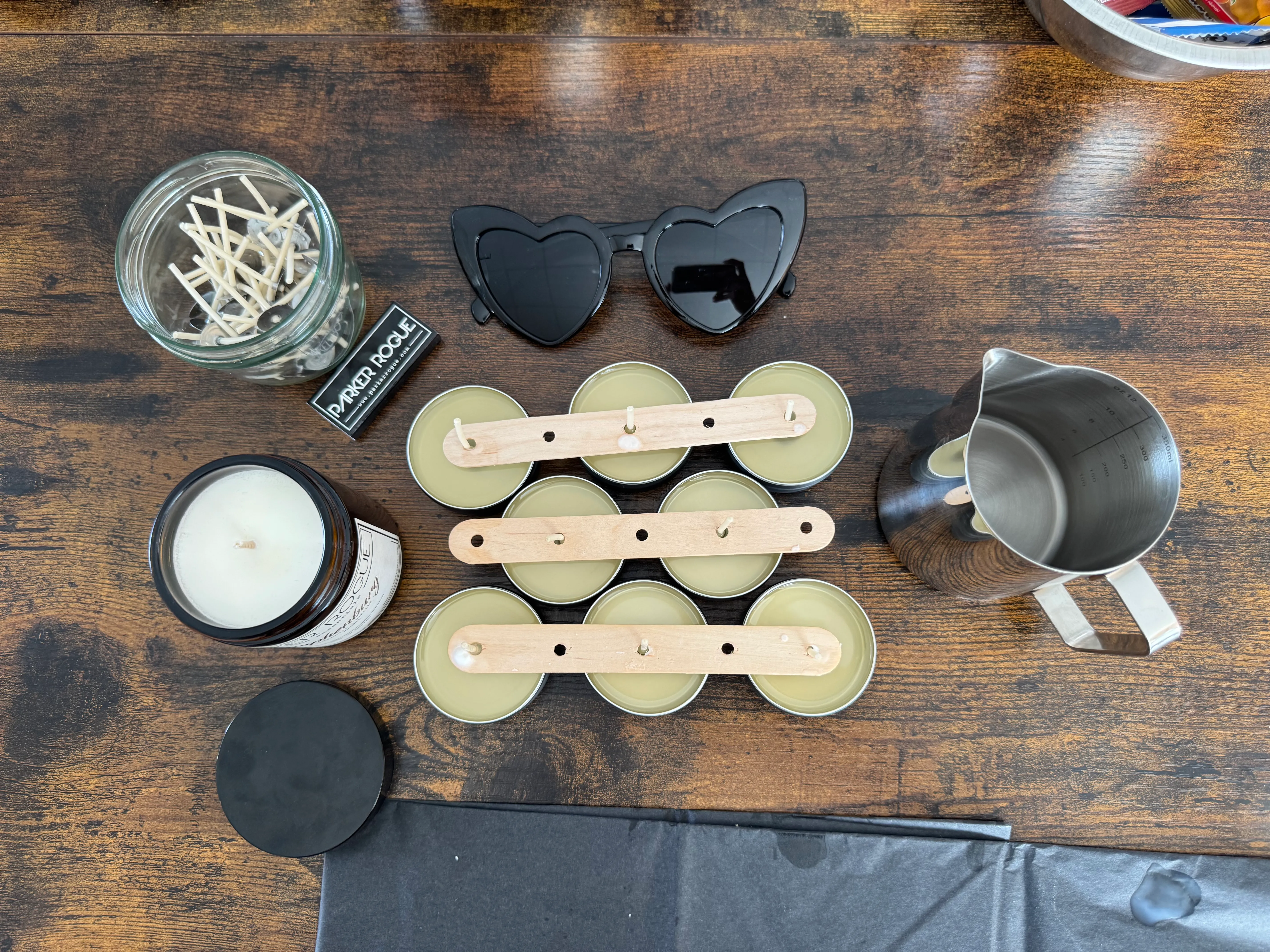 Candle-making supplies on wooden table.