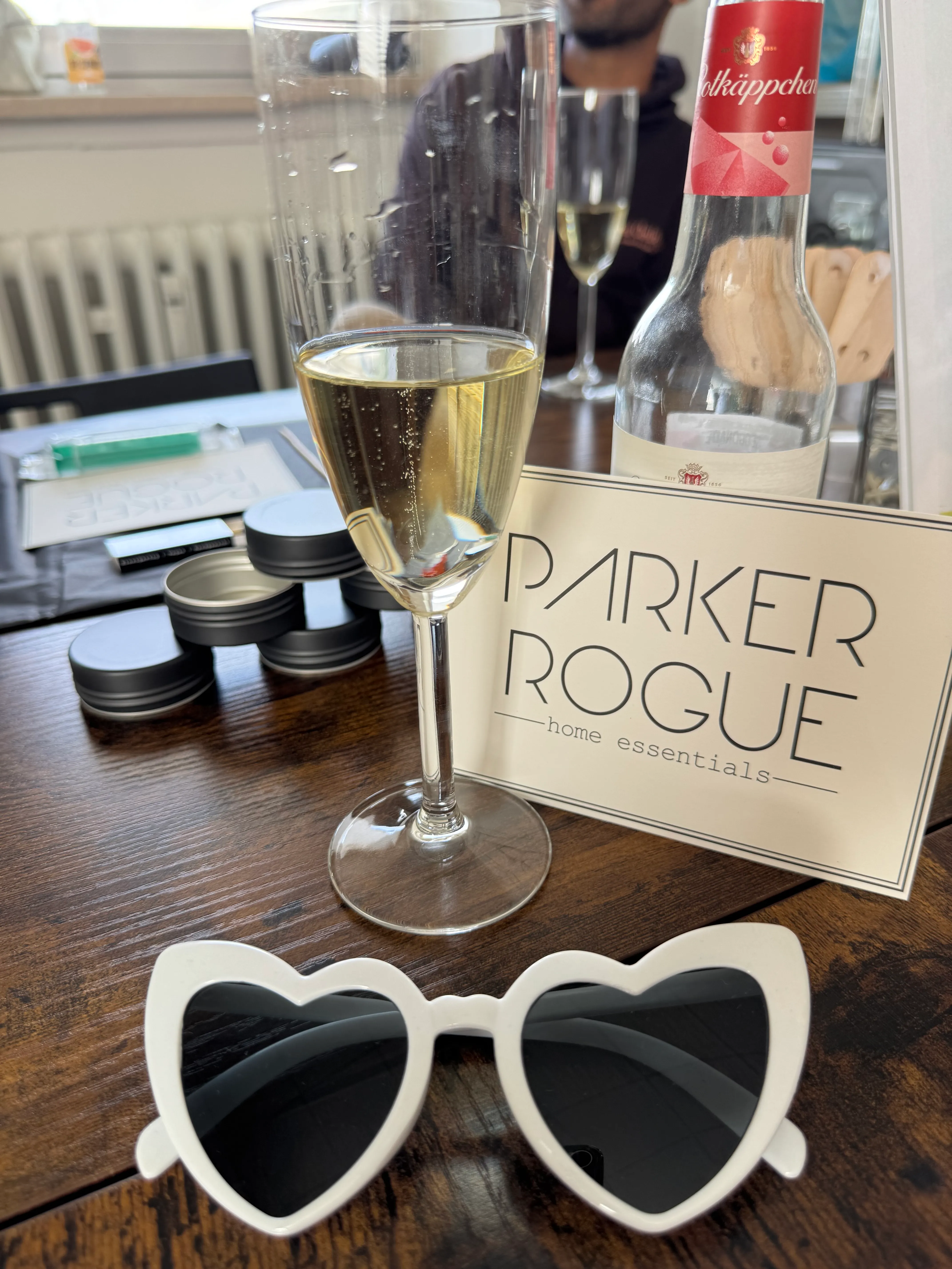 Sunglasses and drink on wooden table.