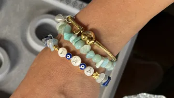 Arm wearing three decorative bracelets.