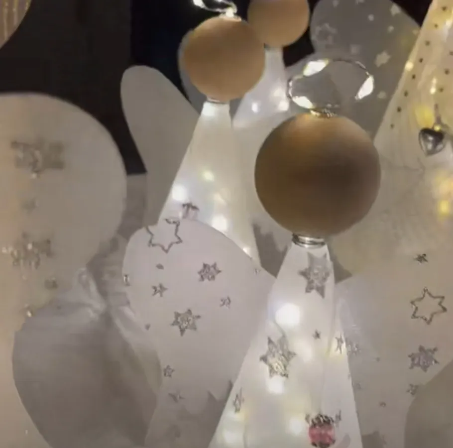Illuminated angel figures with star decorations.