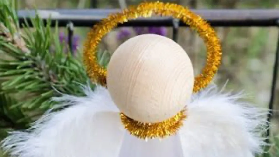 Weihnachtsengel-Anhänger mit goldener Krone draußen.