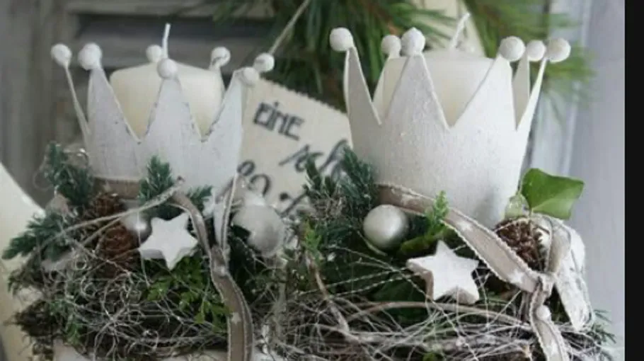 Decorative candles with crowns and greenery.