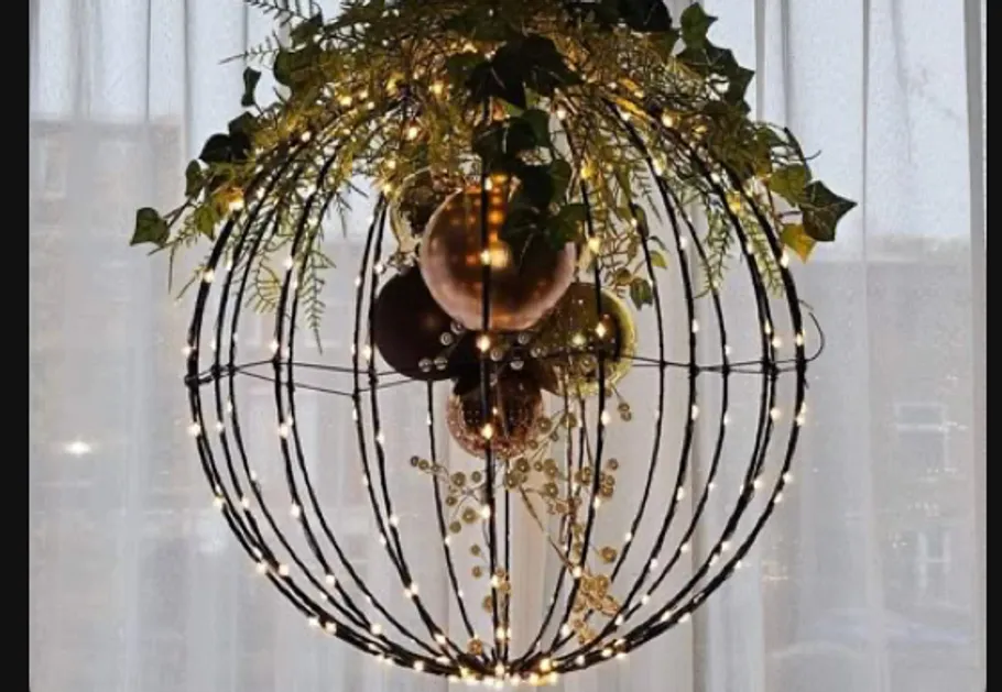 Decorative globe with lights and foliage indoors.