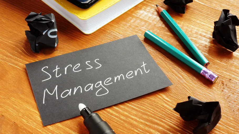 Card with 'Stress Management' on wooden desk.