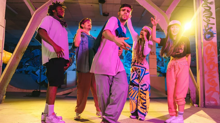 Group of dancers posing in colorful urban setting.